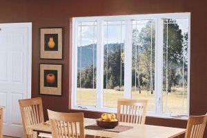 Dining room of home with large white vinyl-framed windows.