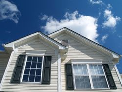 A Home Exterior With Attractive White Siding and Blue Sky in the Background