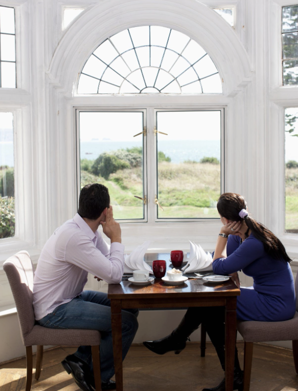 couple enjoying breakfast by a bay window