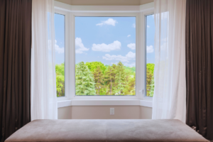 a bay window open and facing beautiful green trees