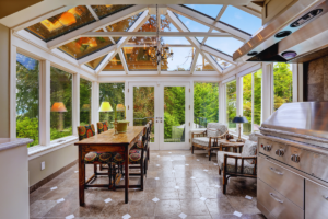 a beautiful solarium style sunroom with cathedral roof and grilling area